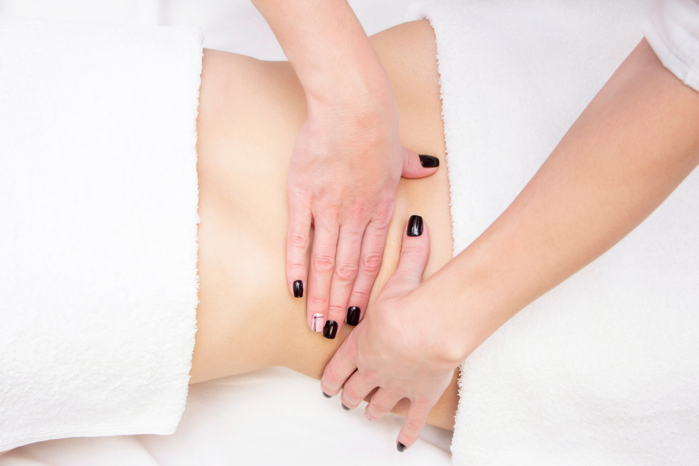 Massage Therapist Massaging a Womens Stomach. Massage and body care. Spa body massage woman hands treatment.